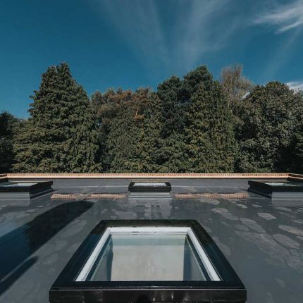 B2B flat roof membrane installation featuring integrated skylights for improved thermal efficiency by our expert contractors.