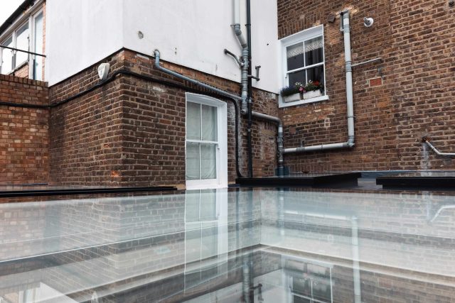 A modern flat roof in Notting Hill, London, featuring newly installed electric Velux skylights and a single-ply membrane.