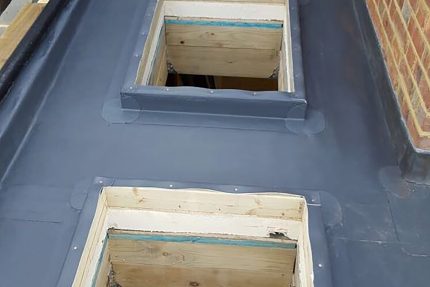 Flat roof replacement in Chiswick featuring newly fitted Velux skylight windows for natural interior lighting.