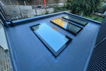 Professional flat roof installers replacing an old, leaking roof with a durable, watertight membrane.