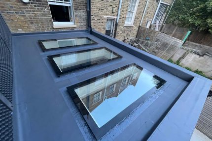 High-quality flat roofing materials expertly installed around a new skylight to prevent water damage.