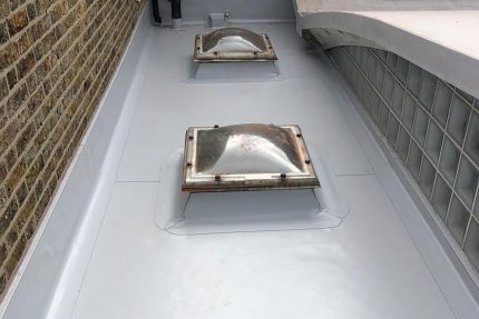 Light grey single-ply roofing membrane installed to manufacturer specifications for superior weather protection.
