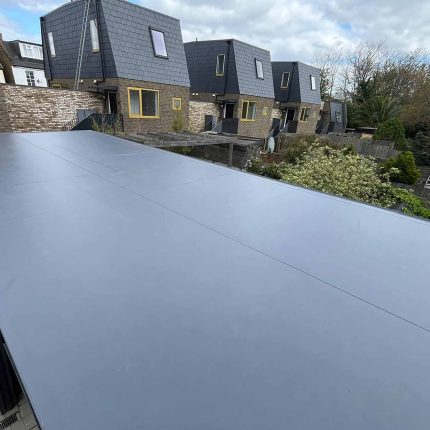Premium grey single-ply membrane flawlessly installed by our commercial flat roofer london specialists on an industrial structure in Barnes.