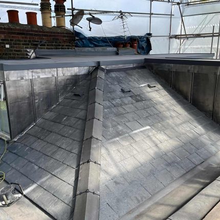 Detailed view of advanced flat roof membrane applications and architectural lead detailing completed on a commercial structure by our North London specialists.