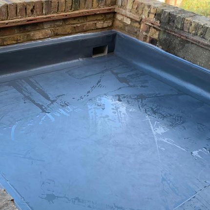 Commercial-grade liquid waterproofing membrane application on a balcony structure, demonstrating the meticulous technical precision of our flat roofer london experts.