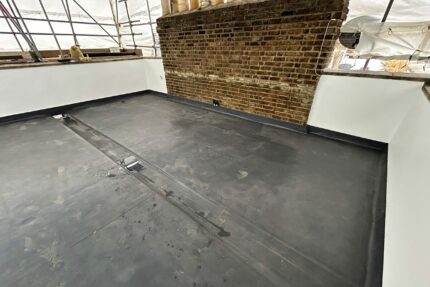 Warm flat roof membrane, perimeter upstand detailing, and adjoining slate roof in St John's Wood NW8.