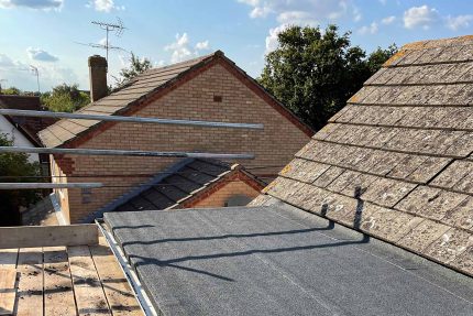 Expert Raynes Park roofers applying a durable, high-performance single-ply flat roof system.