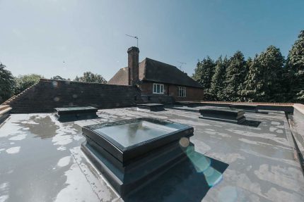 Expert Kingston roofers applying a durable, high-performance single-ply flat roof system.