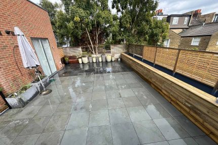 A fully refurbished flat roof terrace in Wimbledon featuring a new Sika single-ply roofing system and clean paving slabs.