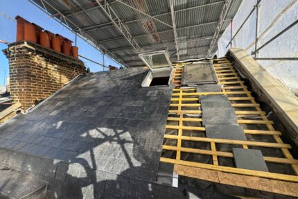 Graded timber roof battens, breathable membrane, and scaffolding during a slate roof replacement in St John's Wood NW8.