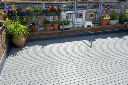 Beautiful bespoke rooftop garden featuring composite decking lounging spaces.