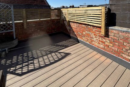 Timber decking and privacy screen integration constructed over a single-ply flat roof system by Hammersmith contractors.