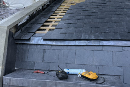 Natural slate tiles laid onto graded wooden battens around a dormer window in St John's Wood NW8.