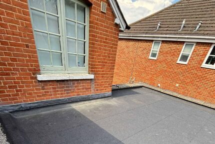 Stripping away the deteriorated existing roofing system before new installation.