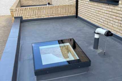 Installing warm roof rigid insulation boards and a vapour control layer over the deck.