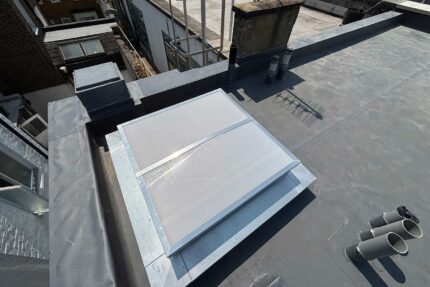 Fitting PIR insulation boards and a vapour control layer for a new warm roof assembly.