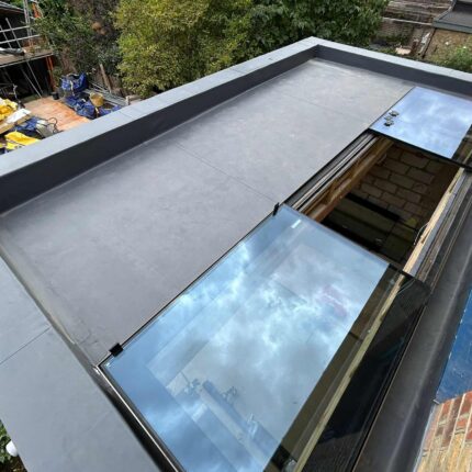 Modern flat roof upgrade in London highlighting sustainable EPDM rubber membranes and a premium sliding glass rooflight for optimal corporate energy efficiency.