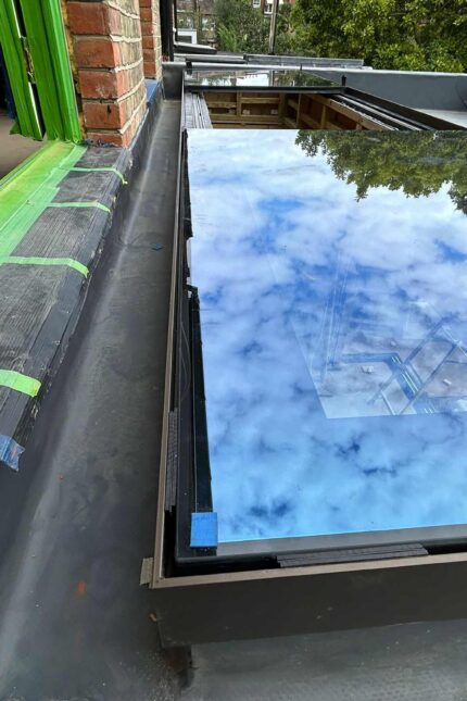 Close-up view of a professional installing a flat roof membrane.