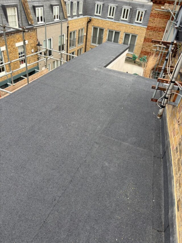 Multi-layer flat roof bitumen membrane bonded securely to structural decking, a premium residential solution delivered by our skilled London roofing installers.