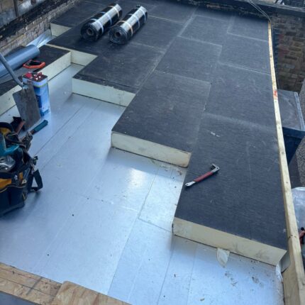 Vapour control barrier and premium rigid insulation being expertly installed on a residential flat roof by our dedicated flat roofer london contractors in Shepherds Bush.