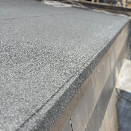 Mineral felt drip edge and bitumen cap sheet forming a watertight perimeter on a residential flat roof engineered by our flat roofer London specialists.