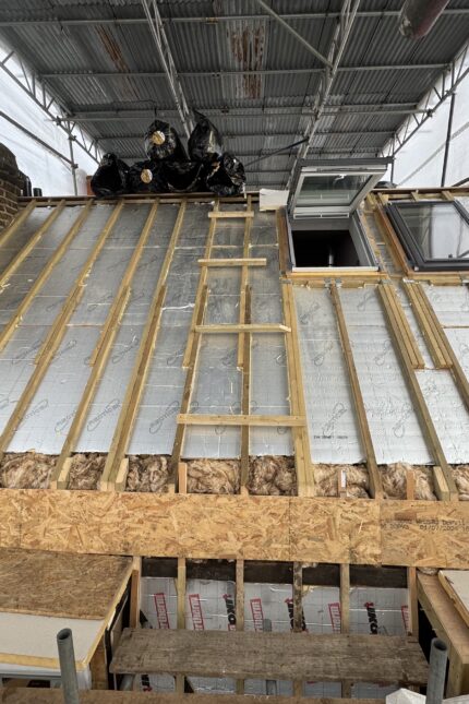 Foil-faced thermal roof insulation and graded BS 5534 timber battens installed during a slate roof replacement in Mayfair W1.